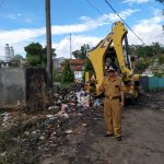 Drs. Tomi Romli Kades Samarang mengeruk sampah dengan alat berat Drs. Tomi Romli Kades Samarang mengeruk sampah dengan alat berat